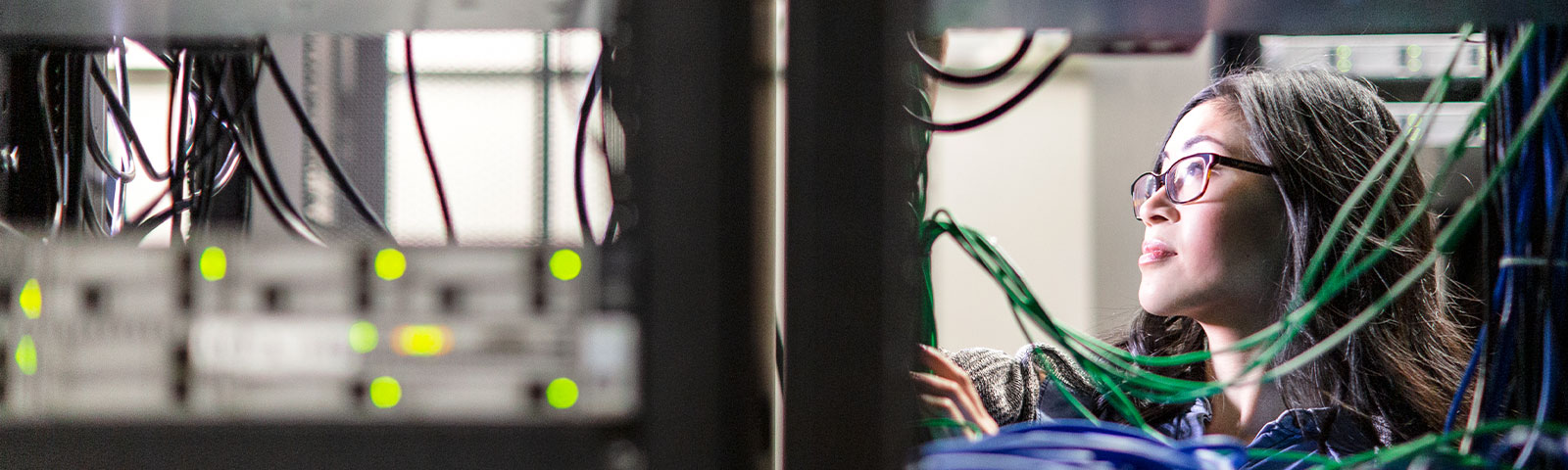 Two workers in a data center with screens and computers