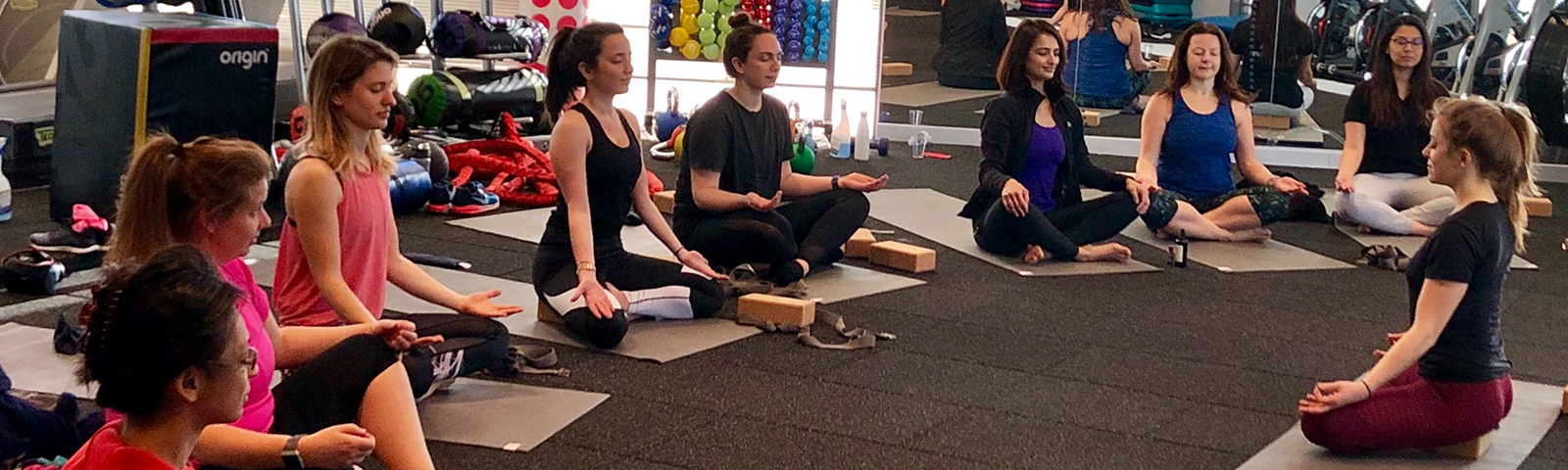 group of people sitting on the ground practicing yoga.