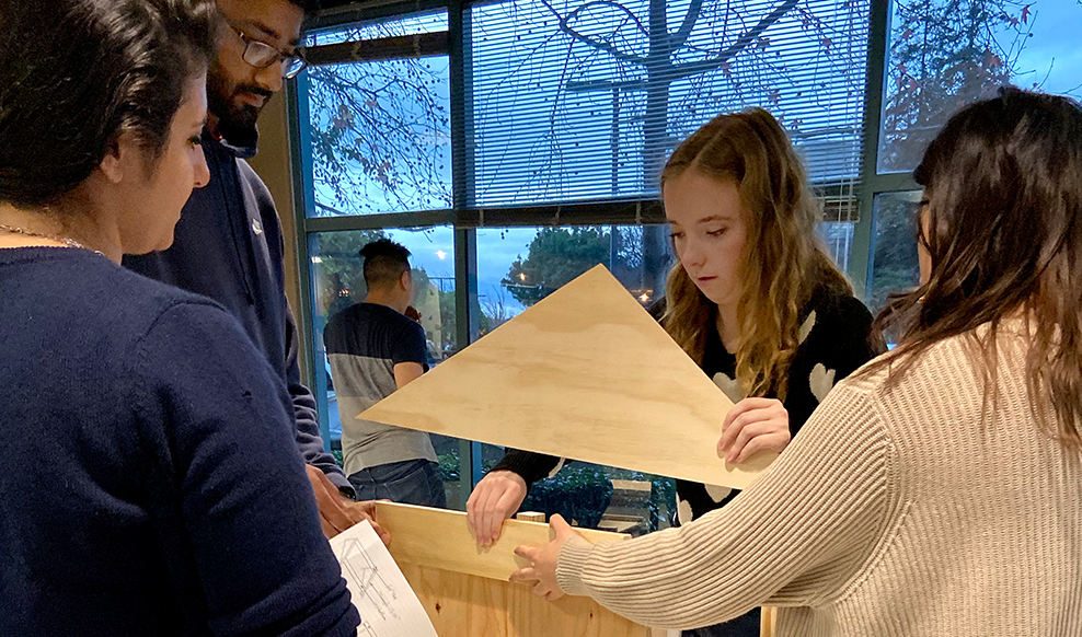 Four people building wood structure for a volunteer activity on Ciscos San Jose Campus