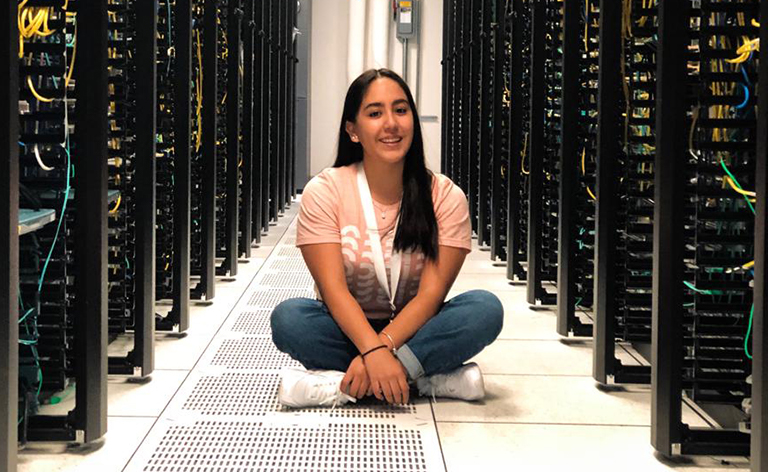 Person sitting in an aisle of Cisco hardware.