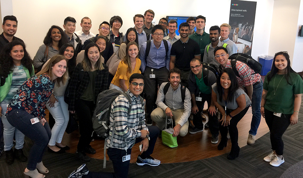 Large group of people huddle together for a photo.