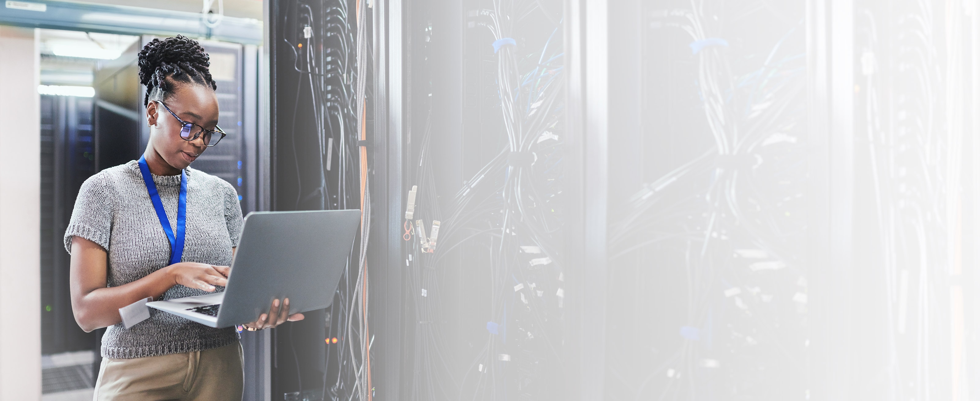 IT worker checking network performance  on a laptop in a server room